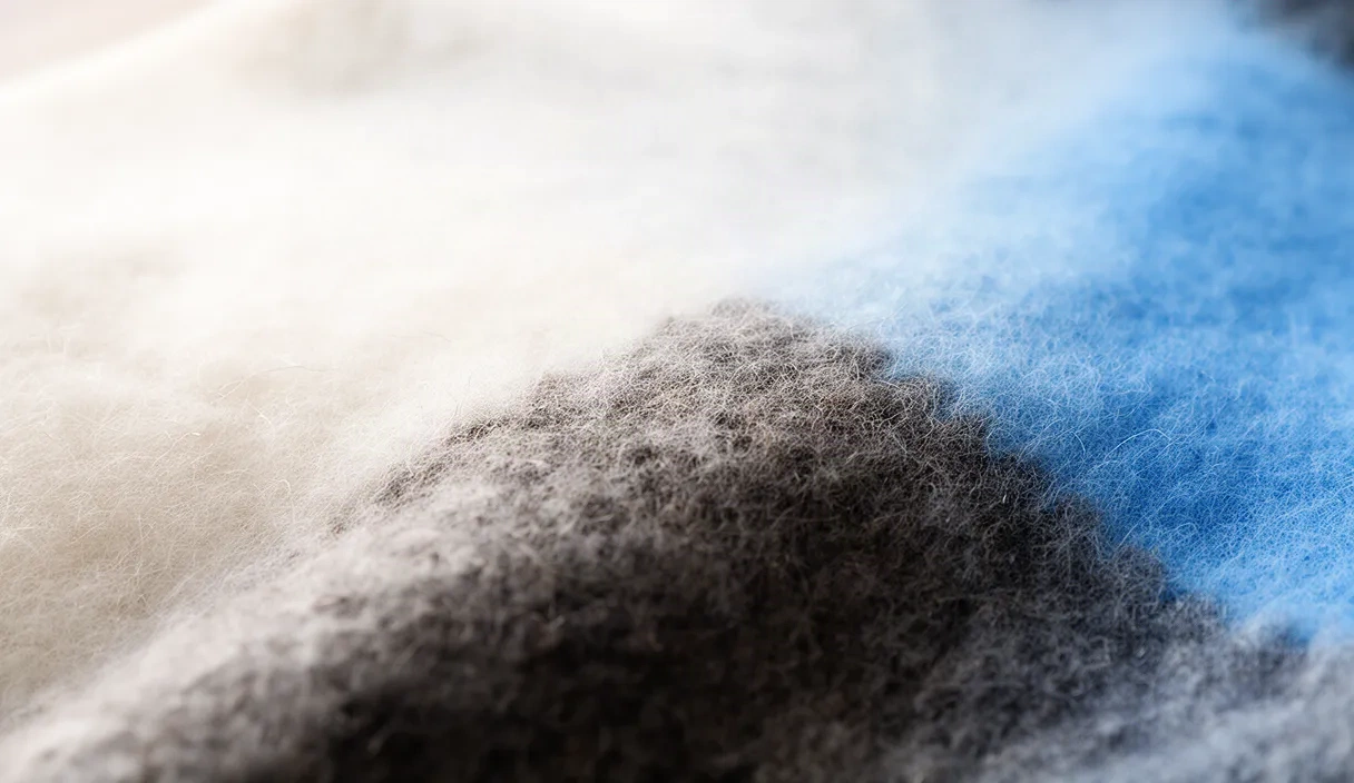 Extreme close-up of various fabric swatches showing detailed weave patterns and textures, including wool, cotton, polyester, and silk materials used in virtual fitting room technology.