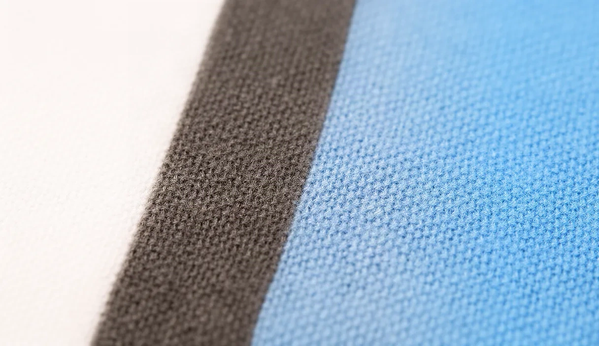 A soft studio-lit macro shot of a fabric swatch and thread, symbolizing virtual outfit try-on.